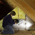 Worker installing insulation in an attic