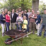 Group of community volunteers with a wheelbarrow at an Earth Day project