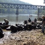 Volunteers removing tires and debris during a river cleanup day