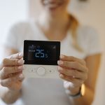 Smart thermostat showing room temperature during a home energy assessment